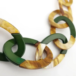 Gros plan sur les maillons ovales du collier en résine avec effet corne et touches de vert foncé, Chez Esprit Brocante et chiné par Mister Broc