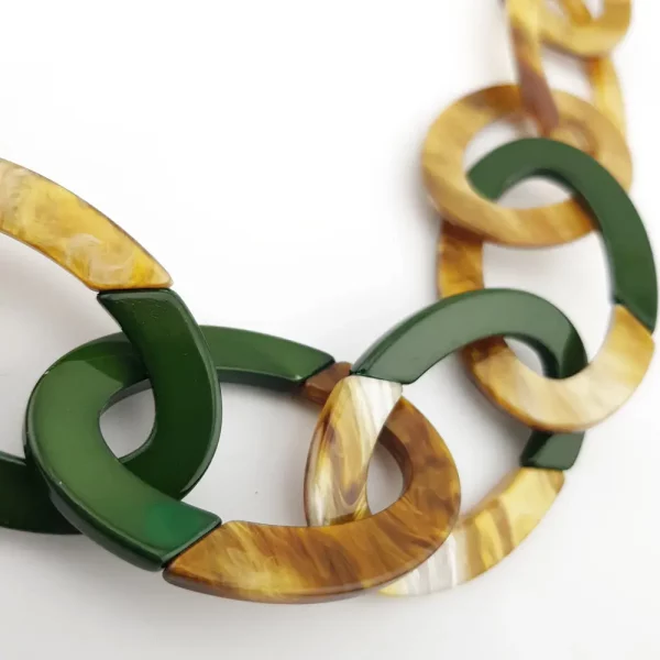 Gros plan sur les maillons ovales du collier en résine avec effet corne et touches de vert foncé, Chez Esprit Brocante et chiné par Mister Broc